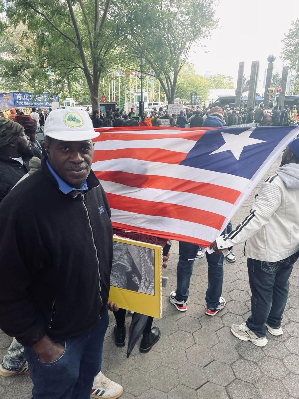 A Liberian diaspora participant holding the national flag near the United Nations plaza