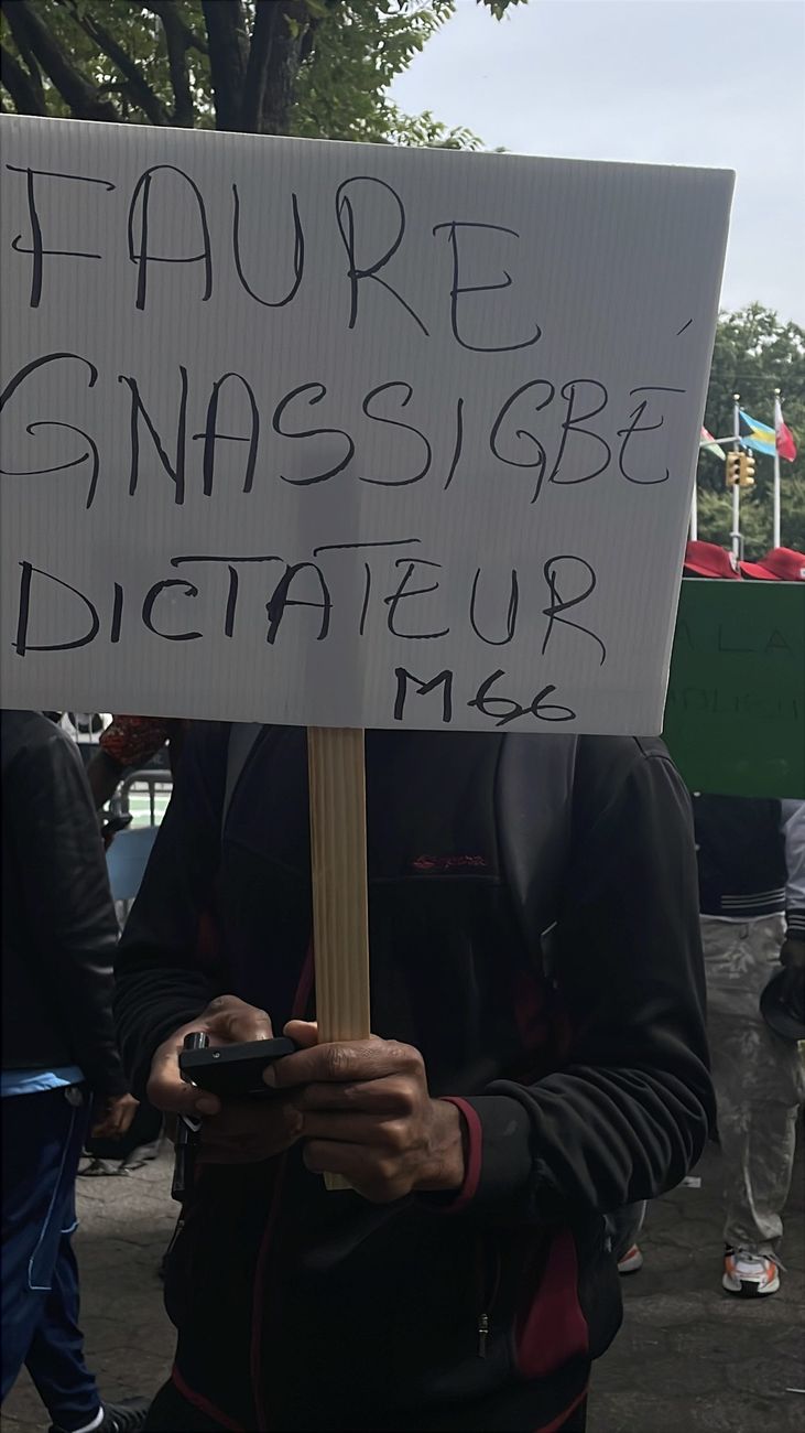 Hand-lettered sign reading Faure Gnassingbe Dictateur M66